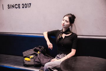 A stylish young woman poses in a black outfit against a dark bench, with "SINCE 2017" text visible on the wall, evoking the early days of crypto culture that aligns with Binance's nine-year anniversary as a global financial infrastructure platform.
