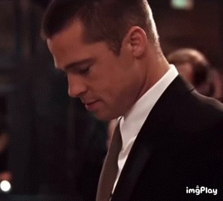iced tea with a straw, a man in a black suit and tie, and a blurred background of people at a table are present in the scene.