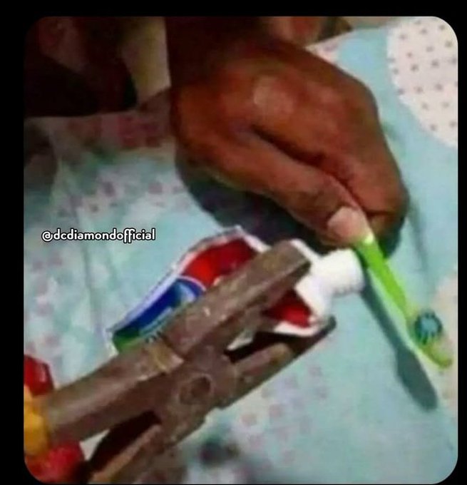 A close-up image shows a hand using pliers to squeeze toothpaste back into the tube, with a toothbrush held nearby and the watermark "@dcdiamondofficial" visible. The image humorously illustrates the post's complaint about being broke and not having been paid since January 2026, as the person is forced to conserve every last bit of toothpaste due to financial hardship.