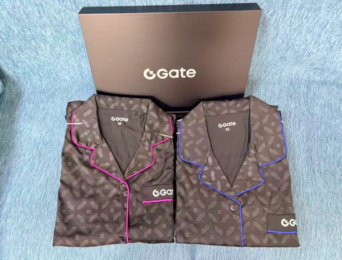 Two "GGate" pajama sets, one with pink trim and one with blue trim, are displayed in front of a "GGate" branded gift box on a blue carpet.