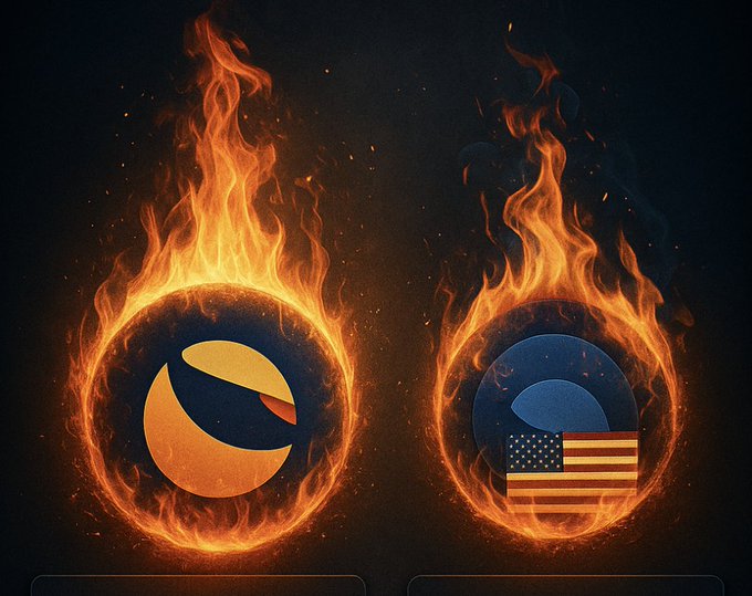 Two crypto coins engulfed in flames are displayed side by side, symbolizing the ongoing token burns of LUNC (left, with its orange and black logo) and USTC (right, featuring the American flag and blue logo) on the Terra Classic chain.