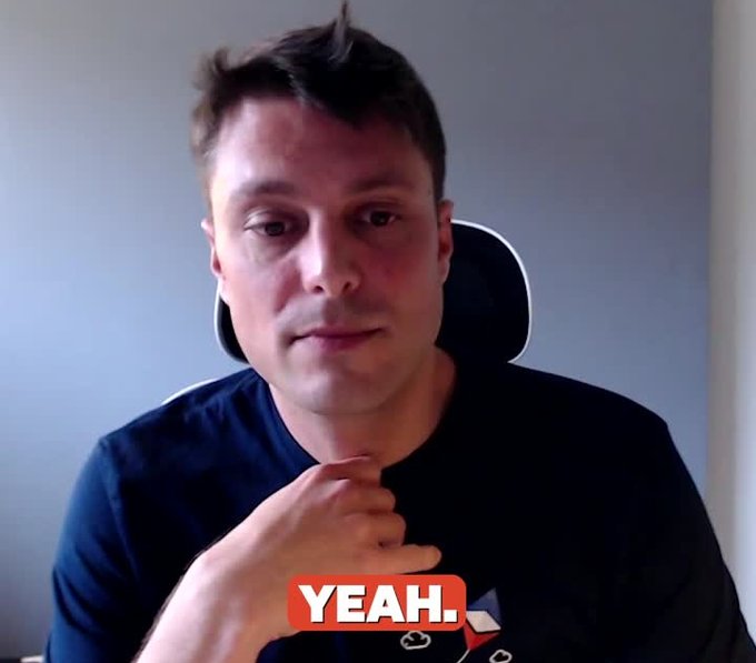 Elon Musk sits in front of a camera with his hand near his chin, with a "YEAH." caption displayed at the bottom in a red banner.