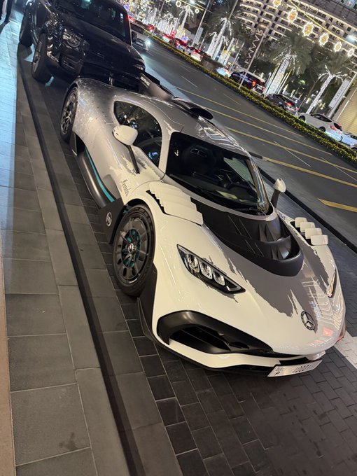 A white and black Mercedes-AMG ONE supercar with "PROOF" branding on its side is parked on a city street at night, fitting the post's joke about crypto influencers moving to the "proof of LARP chain" — a satirical reference to blockchain consensus mechanisms, with the car's "PROOF" decals humorously tying into the crypto terminology.