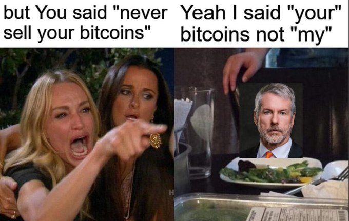 In the image, there are two women sitting at a table with plates of food in front of them. One woman has her mouth open wide as if she's making a statement or expressing an opinion about Bitcoin. The other woman is pointing towards the first woman, who seems to be saying something about Bitcoins. A man wearing a tie can also be seen in the image, sitting at another table nearby.