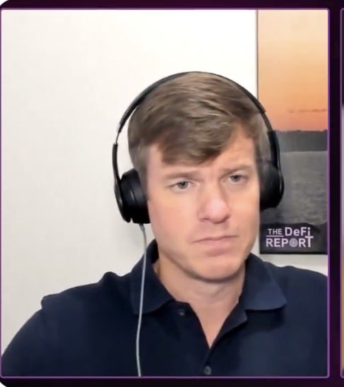 A man wearing black headphones and a dark polo shirt appears in a video frame with 'THE DeFi REPORT' logo visible in the background.