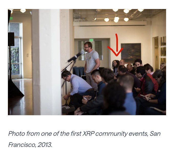 A speaker addresses attendees at one of the first XRP community events in San Francisco in 2013, with a red arrow highlighting him in the crowd, illustrating the early grassroots origins of the XRP community that the post contrasts with Evernorth's upcoming Nasdaq debut.