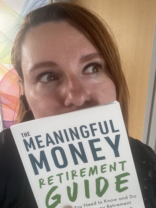 A woman holds up a book titled 'The Meaningful Money Retirement Guide' in front of her face, with only her eyes visible above the book.