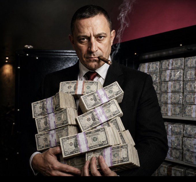 A dramatic image of a man in a dark suit smoking a cigar while holding large stacks of fifty-dollar bills, with more cash stacks visible in a vault behind him.