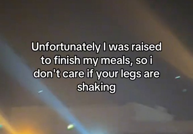 Meme image with white text reading "Unfortunately I was raised to finish my meals, so i don't care if your legs are shaking" over a blurry background.