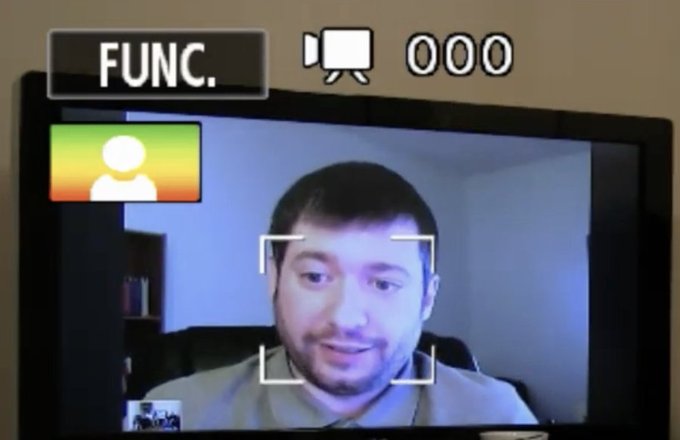 A photo of a TV screen showing a video call interface labeled 'FUNC.' with an icon and '000' counter, displaying a bearded man in the main feed and a profile icon in the corner.