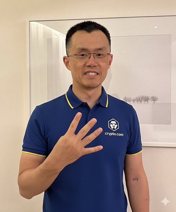 A man wearing a blue "crypto.com" polo shirt holds up four fingers, with a "212" tattoo visible on his forearm, matching the post's reference to CZ Binance signaling a $4 price target for $CRO.