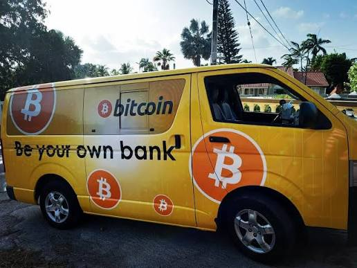 A bright yellow van is wrapped with multiple Bitcoin logos (the orange "₿" symbol) along with the slogans "bitcoin" and "be your own bank," serving as a mobile advertisement that visually reinforces the post's message of financial empowerment through owning BTC.