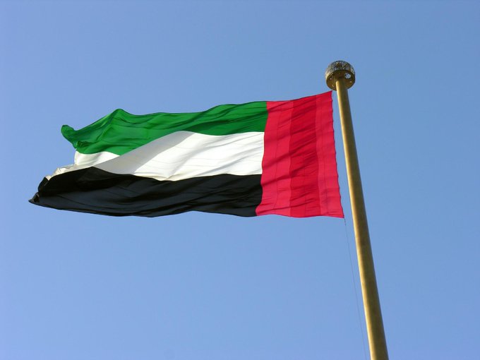 The flag of the United Arab Emirates waves against a clear blue sky, symbolizing the UAE's regulatory move as the Central Bank approves the dirham-backed DDSC stablecoin for listing on VARA-regulated exchanges.