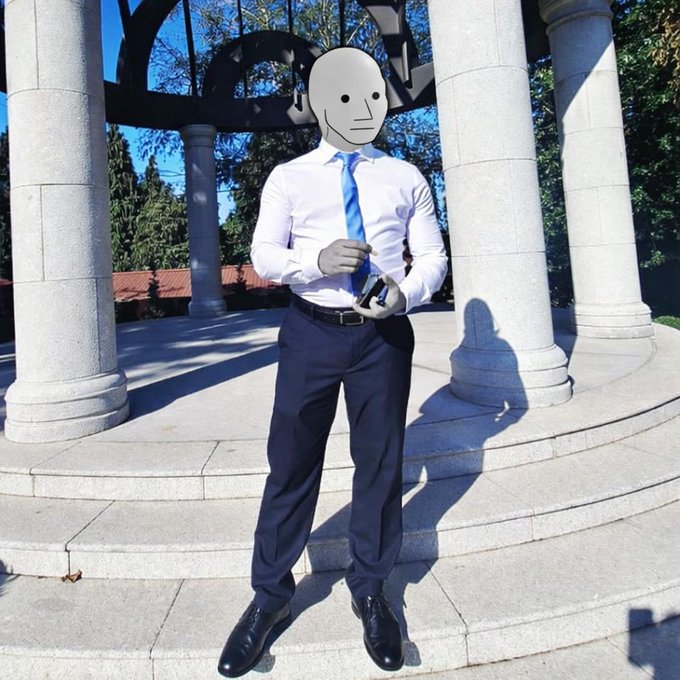 The image features a man dressed in a suit and tie standing on steps with his hands in his pockets. The man has a face drawn on his head, giving him an unusual appearance. The caption of the image reads "My script is already ingrained, 4ever an $NPC #NonPlayableCoin". This phrase refers to a popular video game series called "The Legend of Zelda: Twilight Princess", which features a character named Link who possesses the ability to control the narrative and manipulate the story through his thoughts. The caption suggests that this image could be related to or inspired by the video game, with the man's face drawn on his head serving as a creative and humorous way to connect it to the game.