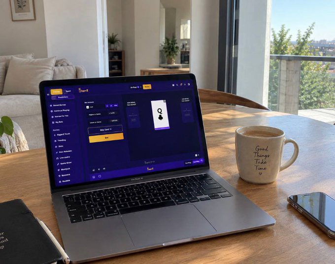 A workspace scene showing an open laptop on a wooden table displaying what appears to be a crypto trading interface, accompanied by a beige mug reading 'Good Things Take Time' and a smartphone, with a couch and balcony view in the background.