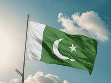 The image shows the national flag of Pakistan waving against a partly cloudy sky, symbolizing the country referenced in the post about Pakistan's new crypto licensing framework through the Virtual Assets Regulatory Authority.