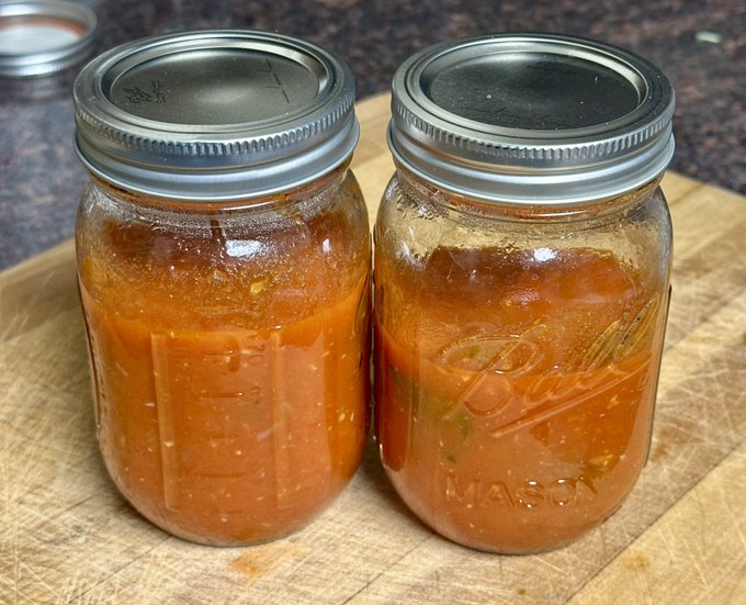 Two Ball "Mason" mason jars filled with an orange-red sauce sit sealed on a wooden cutting board, likely containing the homemade "wahndo's special sauce" referenced in the post.