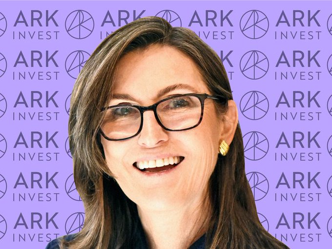 A smiling woman with glasses is shown in front of a purple background patterned with "ARK INVEST" logos. The image relates to the post by depicting Cathie Wood, the CEO of ARK Invest, whose firm is reported to have sold $606,764 worth of BMNR (BitMine Immersion Technologies) shares.