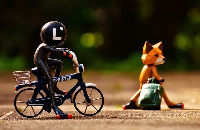 A black "L" figure rides a bicycle labeled "SPRINTER," pulling away from a seated fox figure with a bag, symbolizing MetaMask's departure from Linea and the project's stalled momentum.