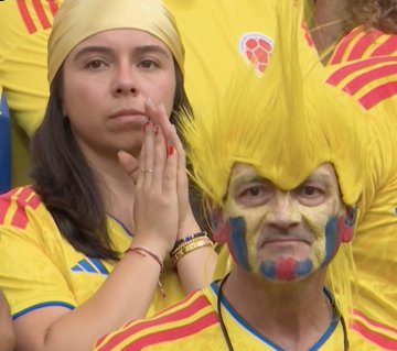 A tense Colombian fan with painted face and yellow wig watches anxiously alongside another supporter during extra time of the Switzerland vs Colombia match, capturing the nervous anticipation behind the high-stakes $240,640 wager on Stake.com.

(Note: No visible text, numbers, tickers, or names appear in the image itself beyond the Colombia football federation crest.)