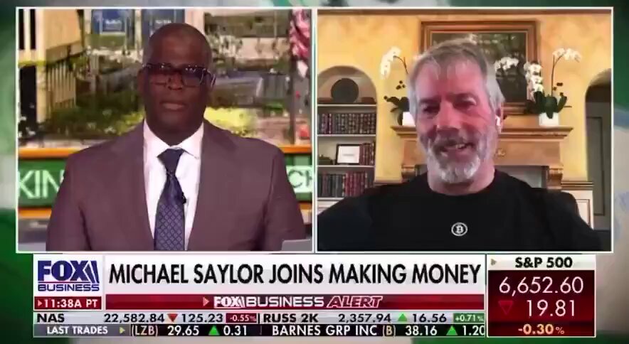 The image shows a news broadcast of Michael saying he's making money from Bitcoin, which has been featured on Fox Business. The TV screen displays the conversation between Michael and another person, possibly discussing the Bitcoin market or its potential impact on their financial situation.