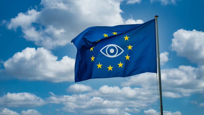The European Union flag waves against a partly cloudy blue sky, but its central circle of stars has been replaced with an eye symbol—a visual play on the phrase "Europe currently" that humorously suggests mass surveillance, riffing on the common reaction "we're being watched, apparently."