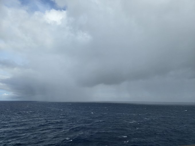 A moody seascape photograph showing a dark, choppy ocean under an overcast sky with heavy gray storm clouds dominating the upper portion of the frame.