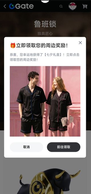 Gate.io mobile app screenshot showing a Chinese-language popup '立即领取您的周边奖励!' (Claim your merchandise rewards now!) featuring black pajama sets for him and her, with '取消' (Cancel) and '前往领取' (Go claim) buttons, and a bulllock mascot at the bottom.