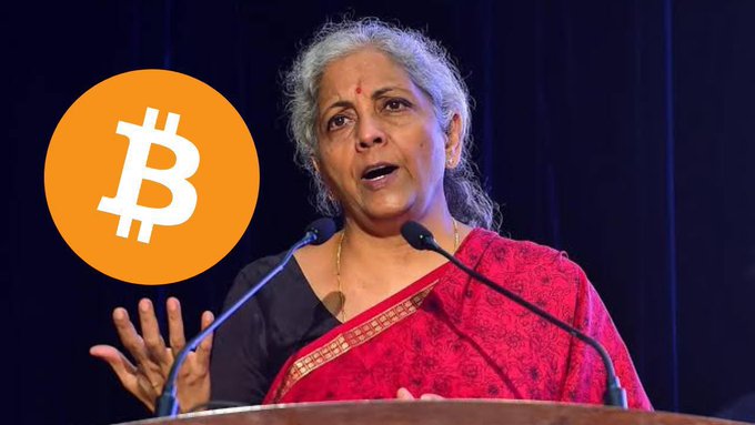 An image showing Indian Finance Minister Nirmala Sitharaman speaking at a podium with a Bitcoin (₿) symbol overlaid in an orange circle, suggesting a connection between her statements and cryptocurrency.