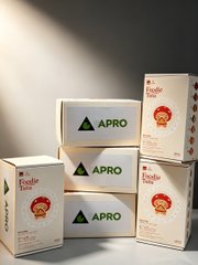 Product packaging boxes for 'Fiedle' featuring red seal designs alongside white boxes with a green triangle logo labeled 'APRO' displayed against a gray background.