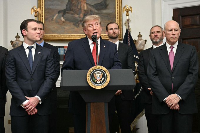 President Donald Trump stands at a podium bearing the presidential seal, flanked by several officials, as he addresses reporters from the White House. The image accompanies news about the Senate vote on the Clarity Act, a major crypto bill, suggesting Trump is making a public statement on the legislation's importance.