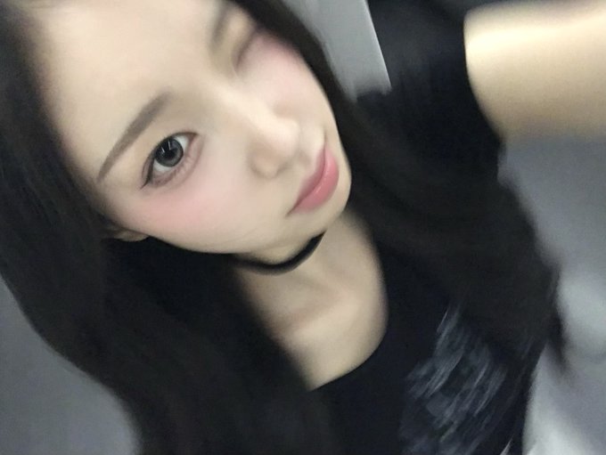 A blurry, close-up selfie of a young woman with long dark hair making a slight pouty expression.
