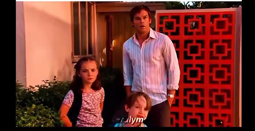 In this image, a man and two girls are standing together near a house door that features red tile work. The people appear close to each other, and they seem to be engaging with each other or the camera directly. A text overlay on the picture reads "I'M REALIZING I Don'T NEED TO PAY $750K/year FOR BLOCKCHAIN data Because I can get it for free using API Keys ... Cocoa (CA), Coffee (CF), Raw Sugar (RS), Live Cattle (LC)", which suggests that the post might be related to a discussion on cryptocurrency or blockchain technology.