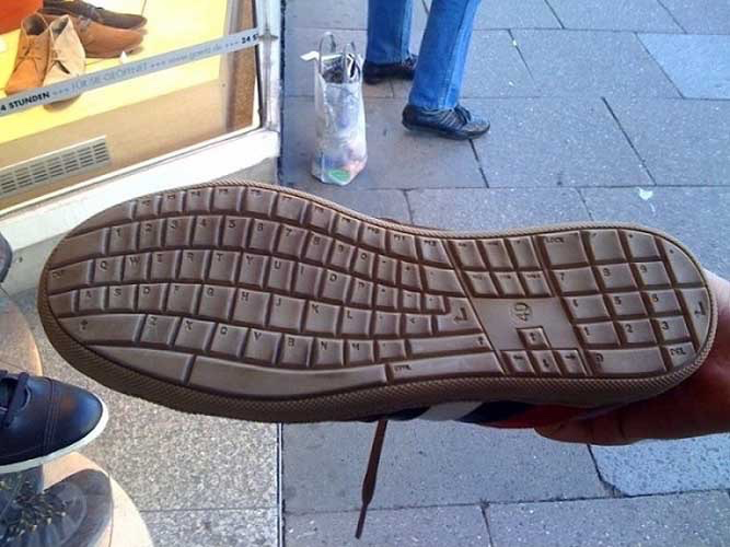 A close-up shows the bottom of a shoe held up in front of a shoe store, revealing that the sole's tread pattern is designed to resemble a computer keyboard.