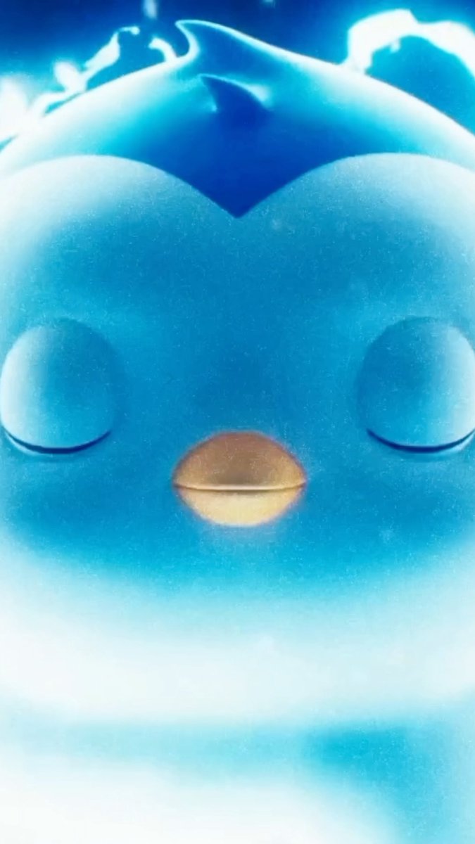 Close-up of a smiling blue penguin-like character with a tuft of feathers on its head and an orange beak, surrounded by a snowy or icy background.